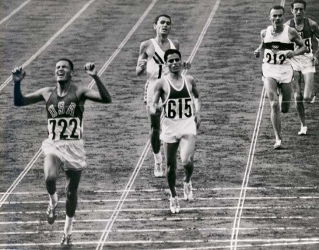 Billy Mills (Oglala Lakota), far left, crosses the finish line in first place during the 10,000 meters at the 1964 Olympic Games in Tokyo. (Photo Official Marine Corps Photo # A411758)