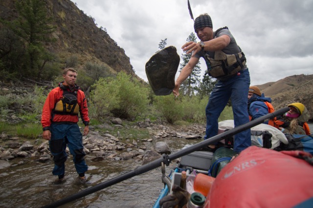 Reid Pletcher (r) hucks a rock in order to dislodge a trapped oar from the raft for the duration of a Mackay Wilderness River Journey. (Photograph: Courtesy Photo)