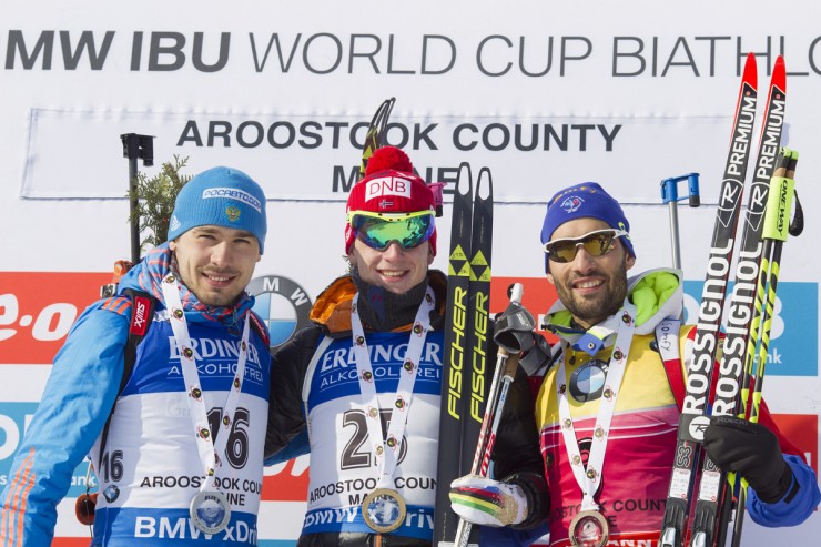The men's sprint podium at the IBU World Cup in Presque Isle, Maine, with Norwegian winner Johannes Thingnes Bø (c), Russia's Anthon Shipulin (l) in second, and France's Martin Fourcade (r) in third. (Photograph: Fischer/NordicFocus)